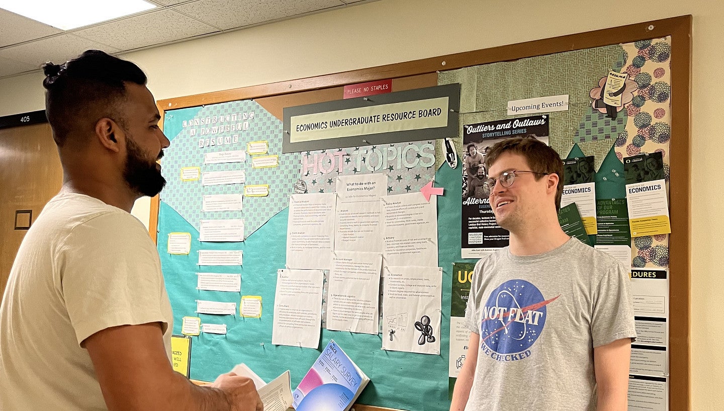 Students talking in front of bulletin board