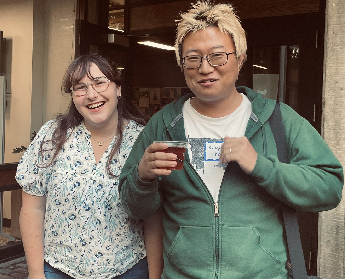 Two students standing outside of McKenzie Hall and smiling at the camera