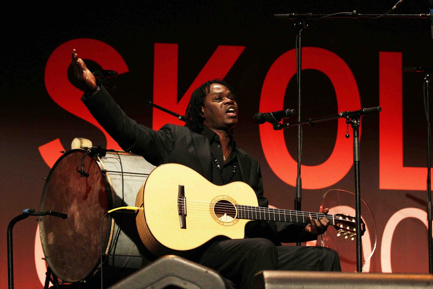 musician on stage with an acoustic guitar