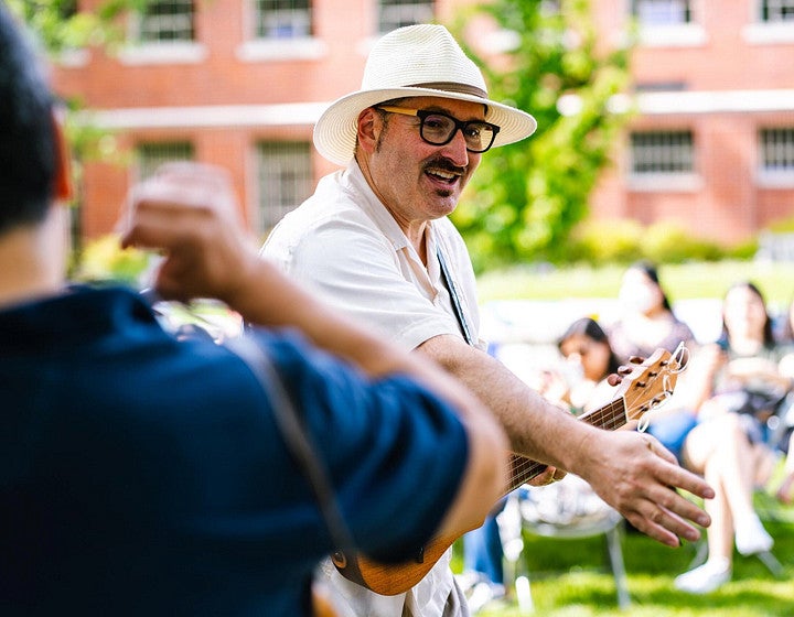 A person playing an instrument at an outdoors event