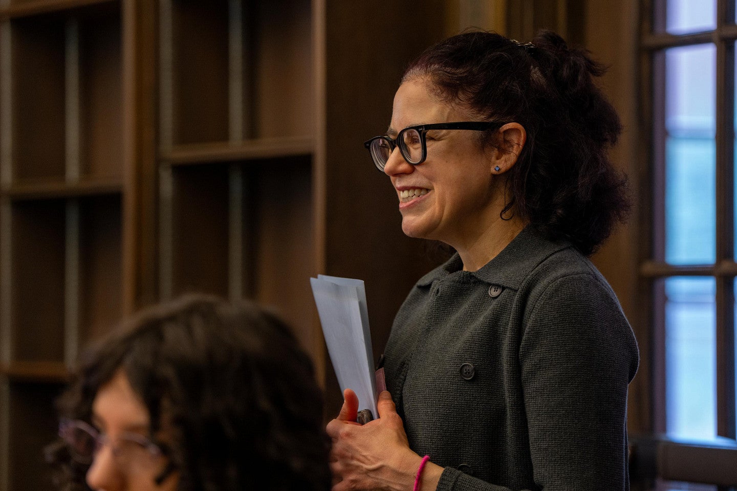 a person wearing glasses and holding a folder