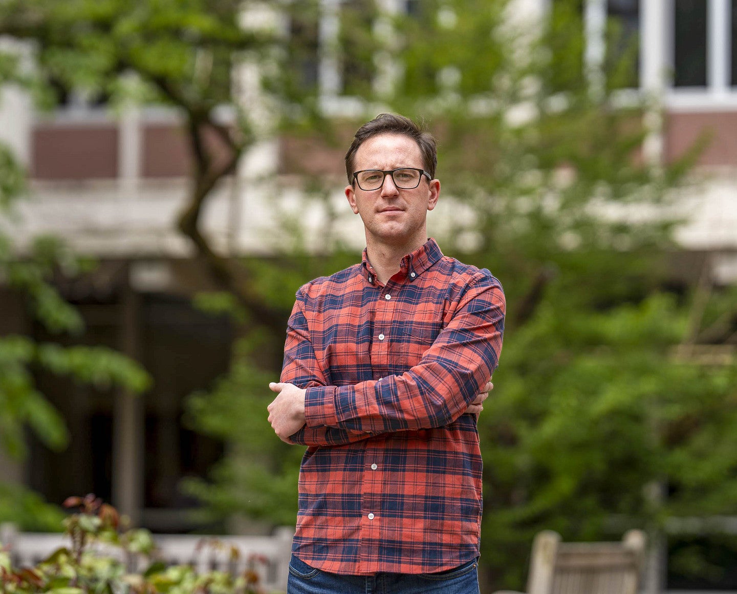 a headshot of a person standing outside a building