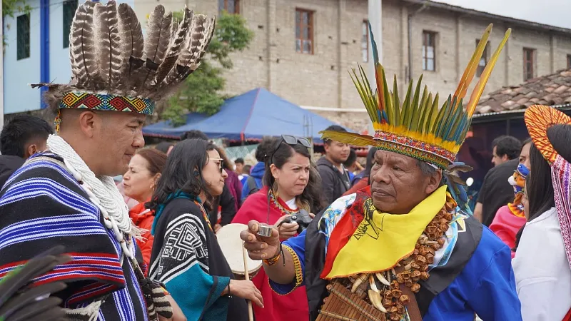 A shaman offers another a shot of aguardiente, a strong Colombian liquor