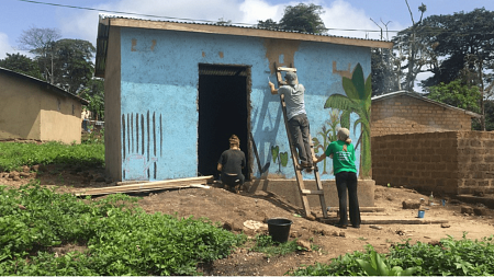 3 people painting blue house