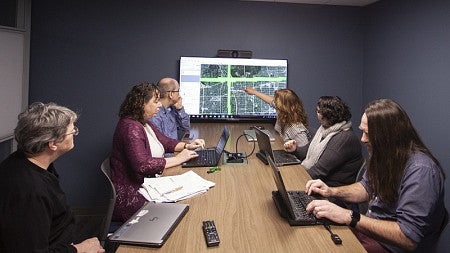 A student presents data on a tv screen 