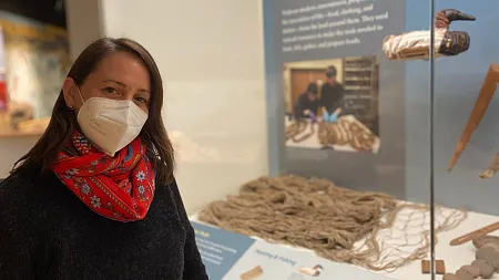 postdoctoral researcher elizabeth kallenbach standing in museum next to display case