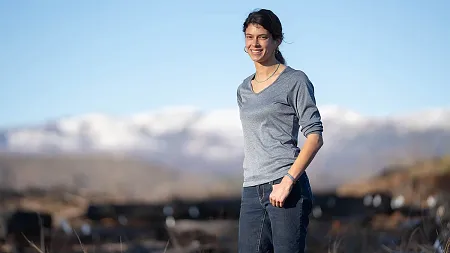 lauren ponisio posing in foreground of mountainous landscape