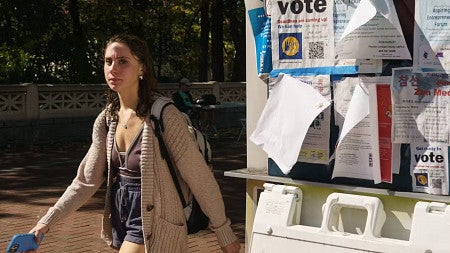 a student walks by posters