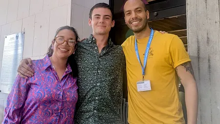 Charles Petrik flanked by two people in a group pose