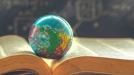 a globe rests on an open book