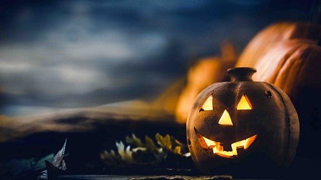 pumpkin lit up in front of a night sky