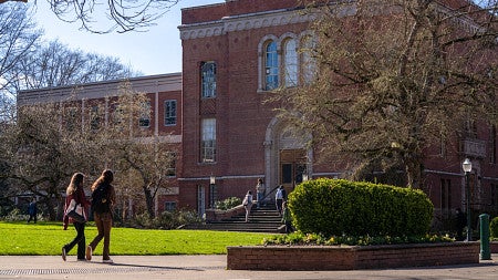 exterior building of Condon Hall with students walking by on a sunny day