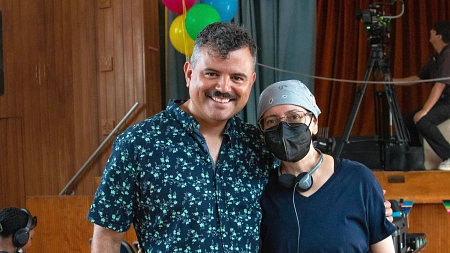 two people standing together in an auditorium 