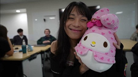 closeup of student hugging plushy for class on Japanese popular culture