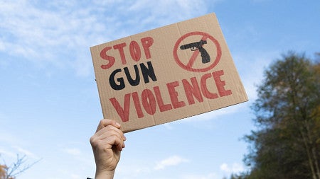 a person holding a sign that says stop gun violence