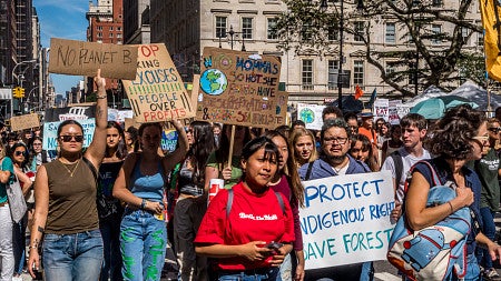 group of protestors marching with signs supporting protecting indigenous rights