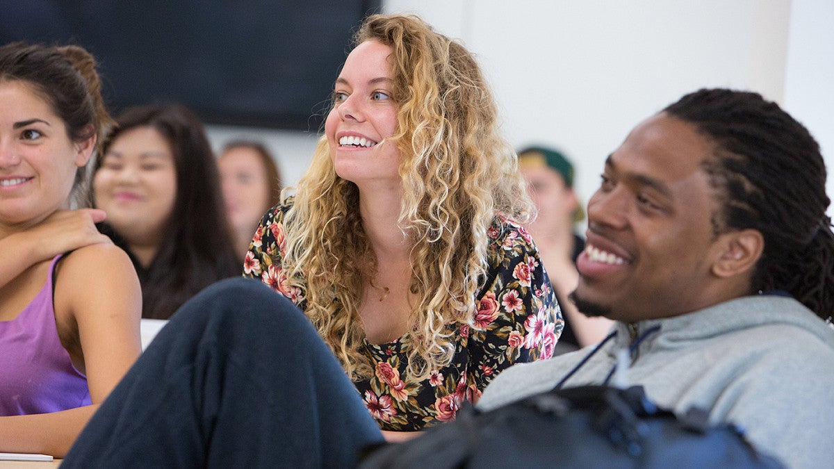 student smiling in classroom around other students