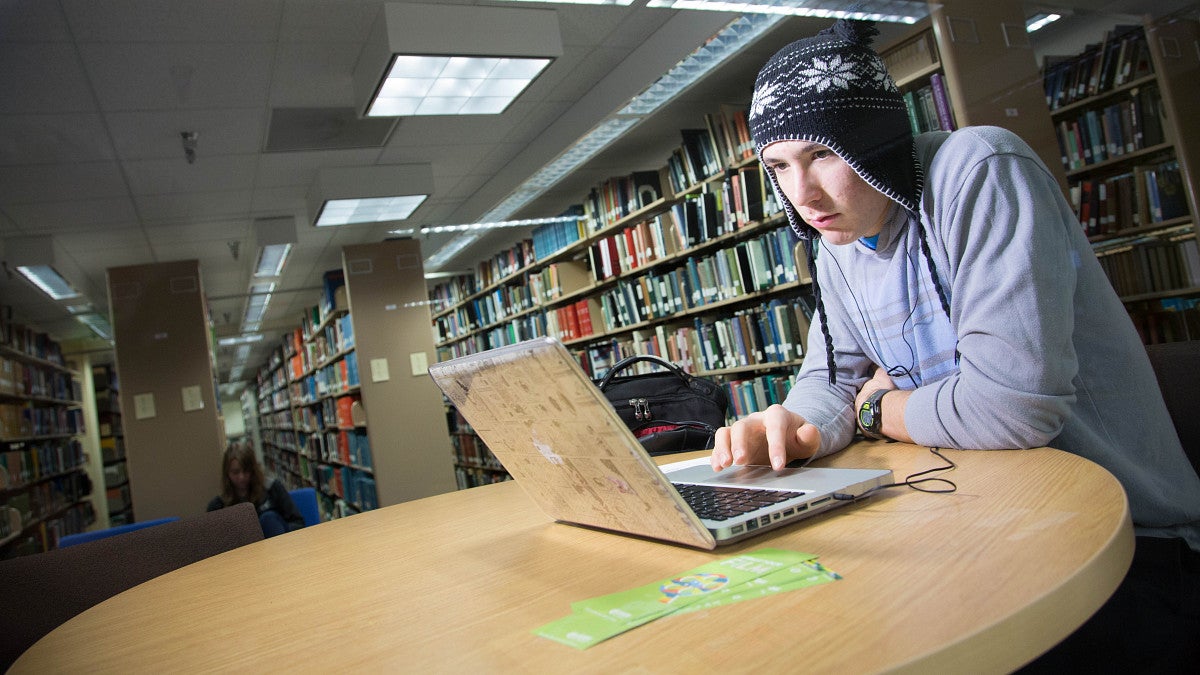 student concentrating while working on laptop