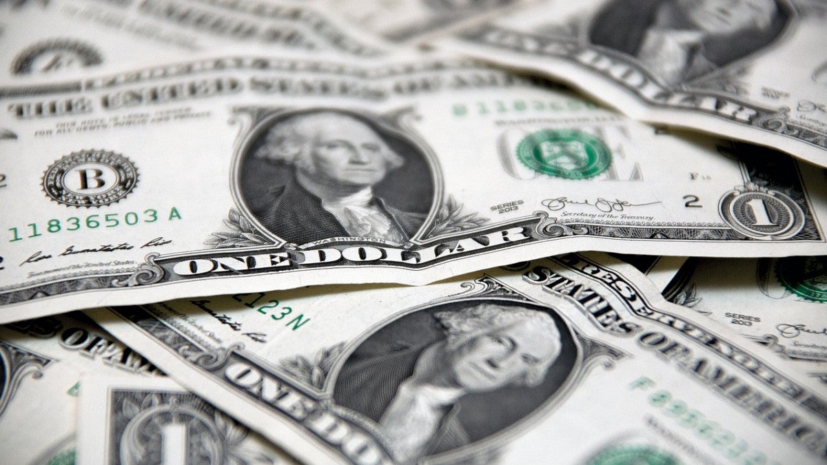 United States one dollar bills laying on top of one another