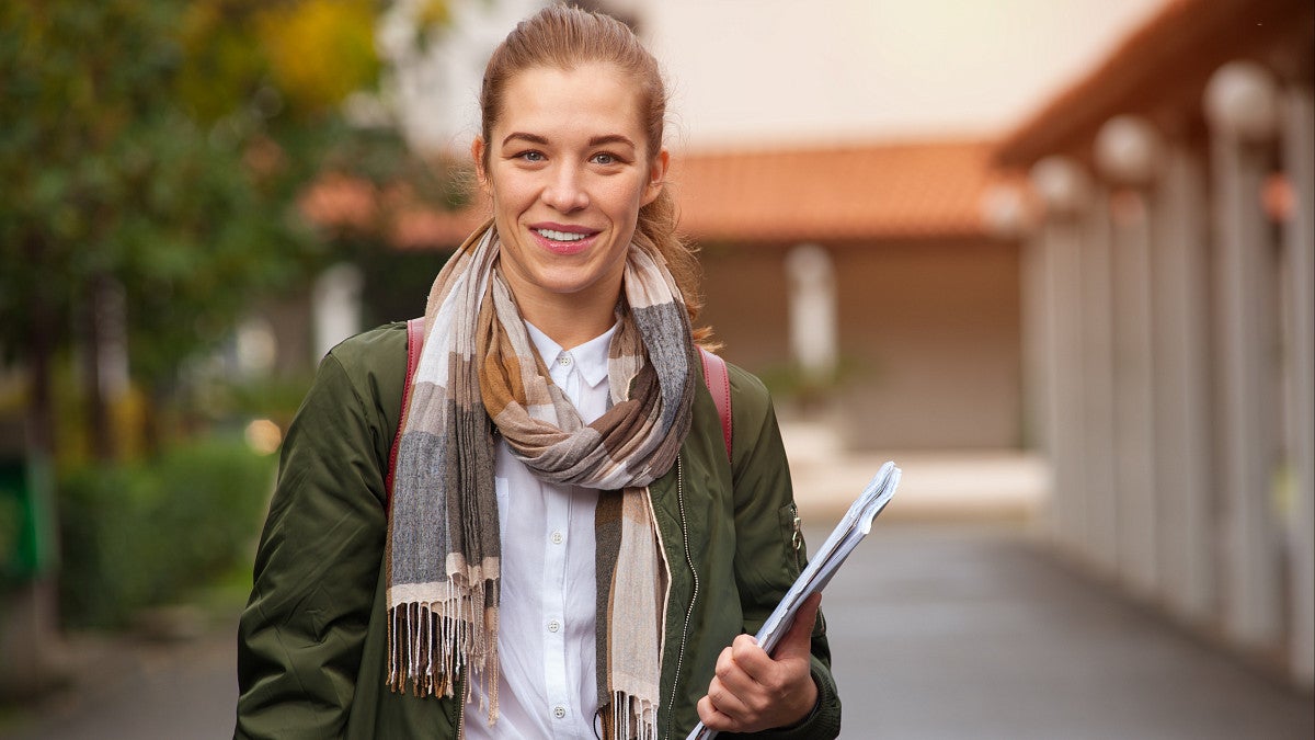 older student on campus with notebook
