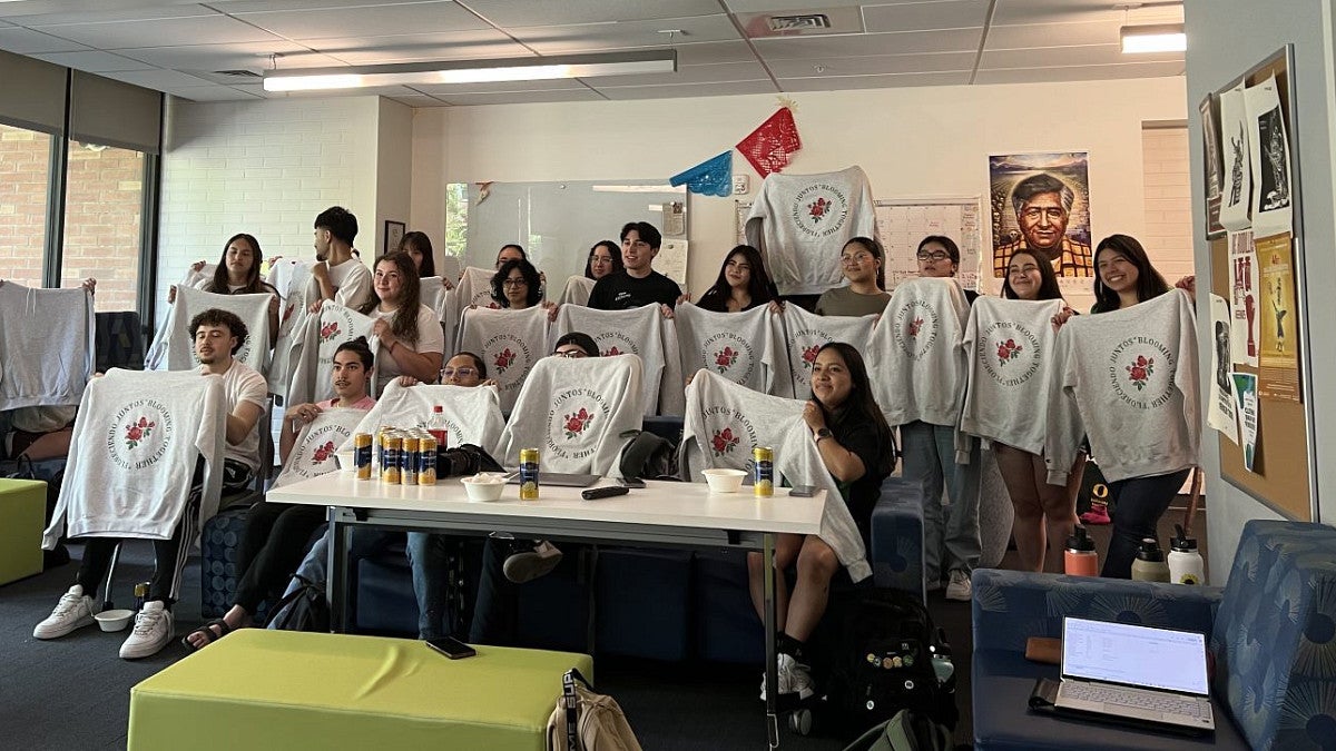 Group of students holding up sweatshirts