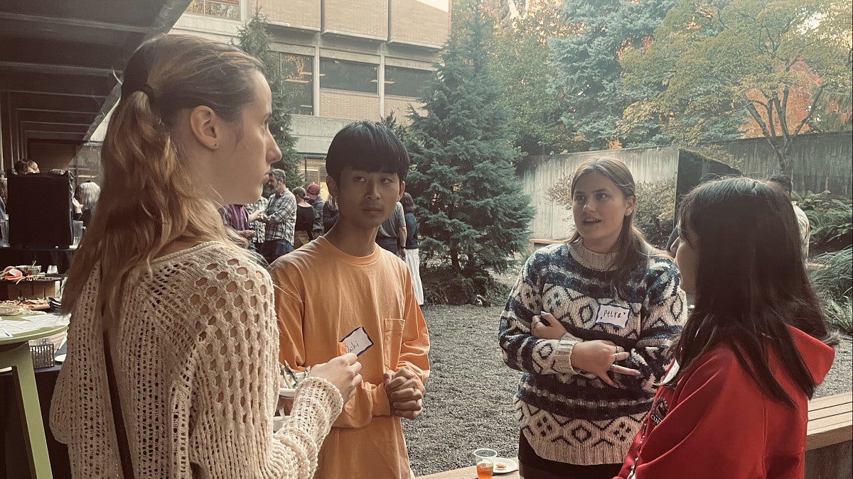 Photo of four students standing in the McKenzie courtyard in conversation