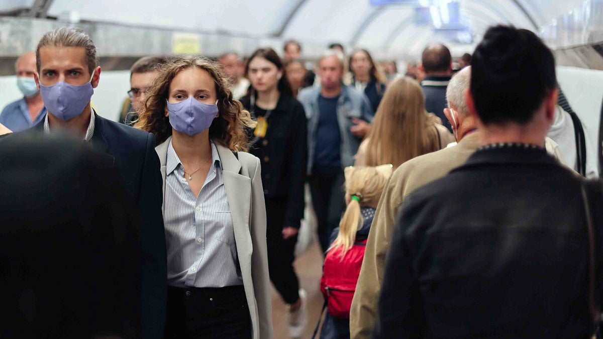 people masked walking through the subway