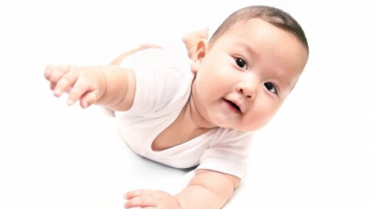 a baby wearing white crawling 