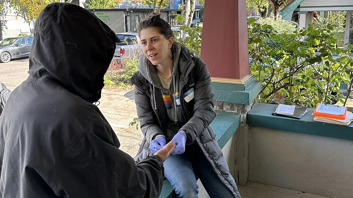 a person with a hood being interviewed 