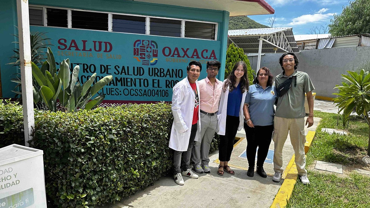 a group of people standing outside a blue building in Mexico