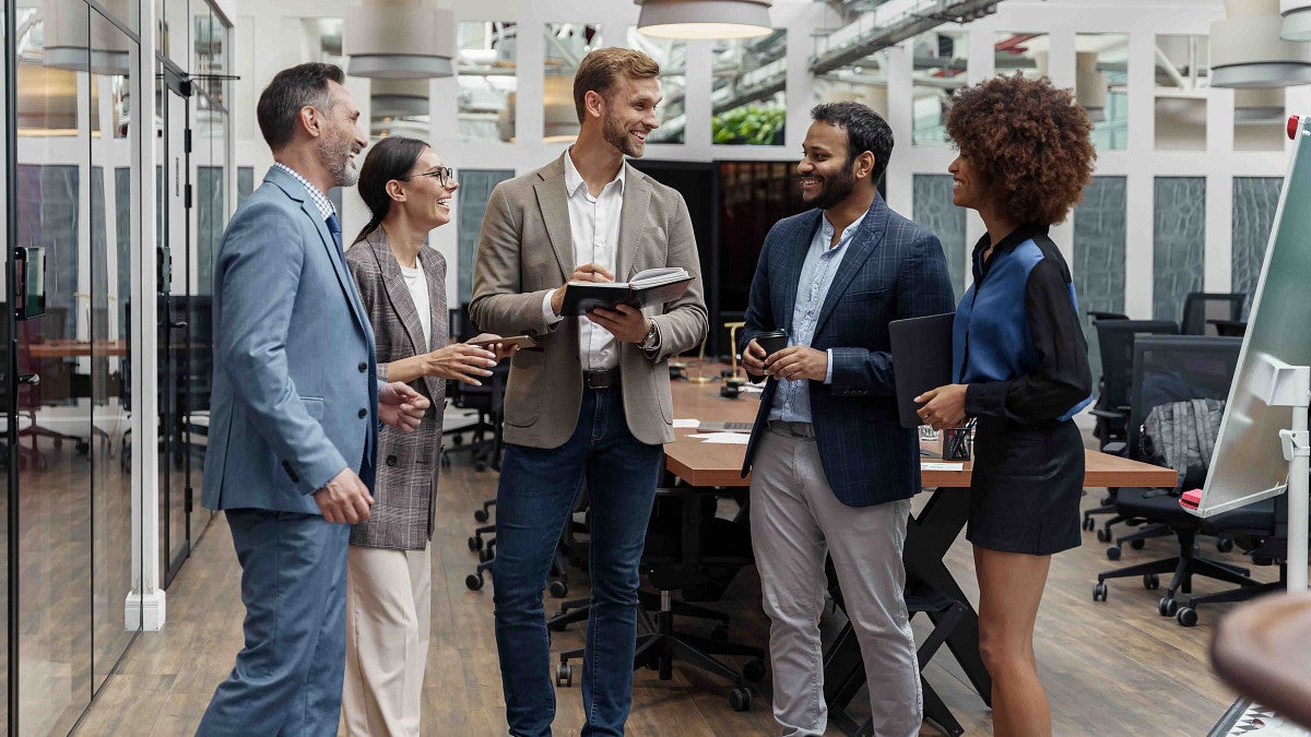 Multiethnic group of business people talking in office during break