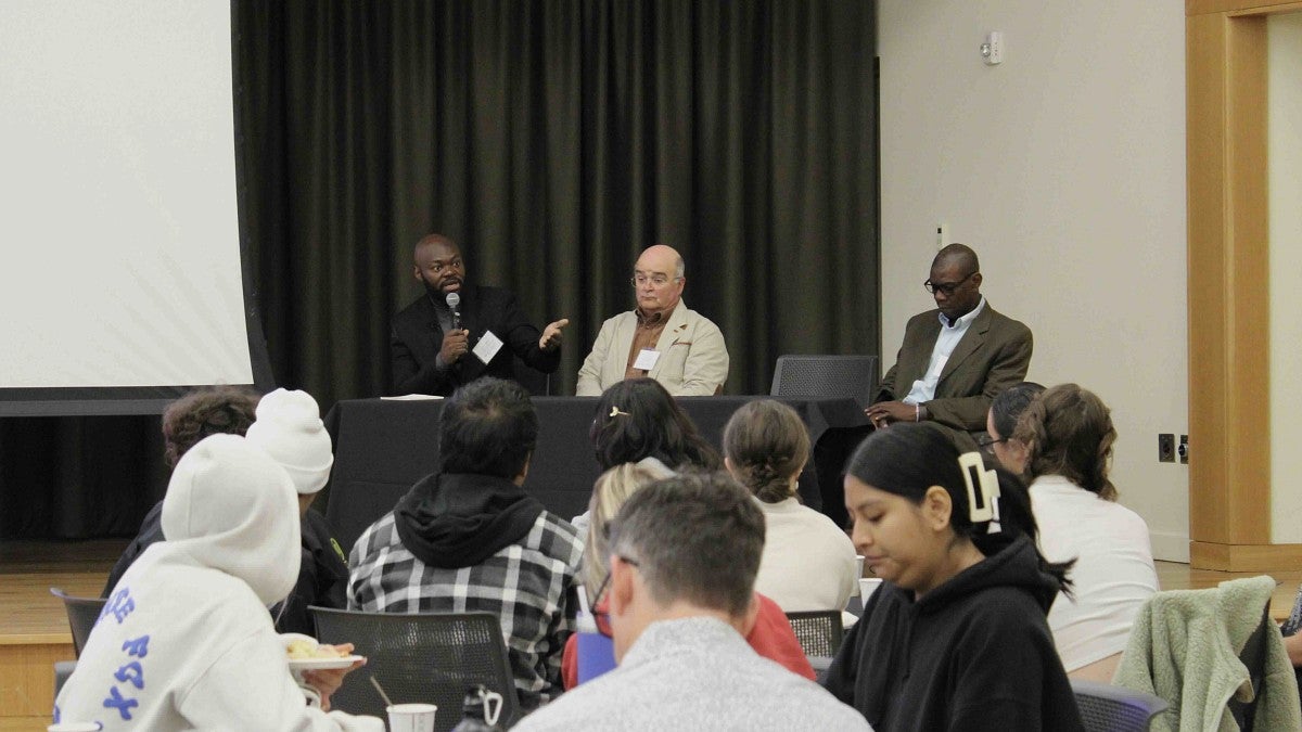 three people discussing on a panel