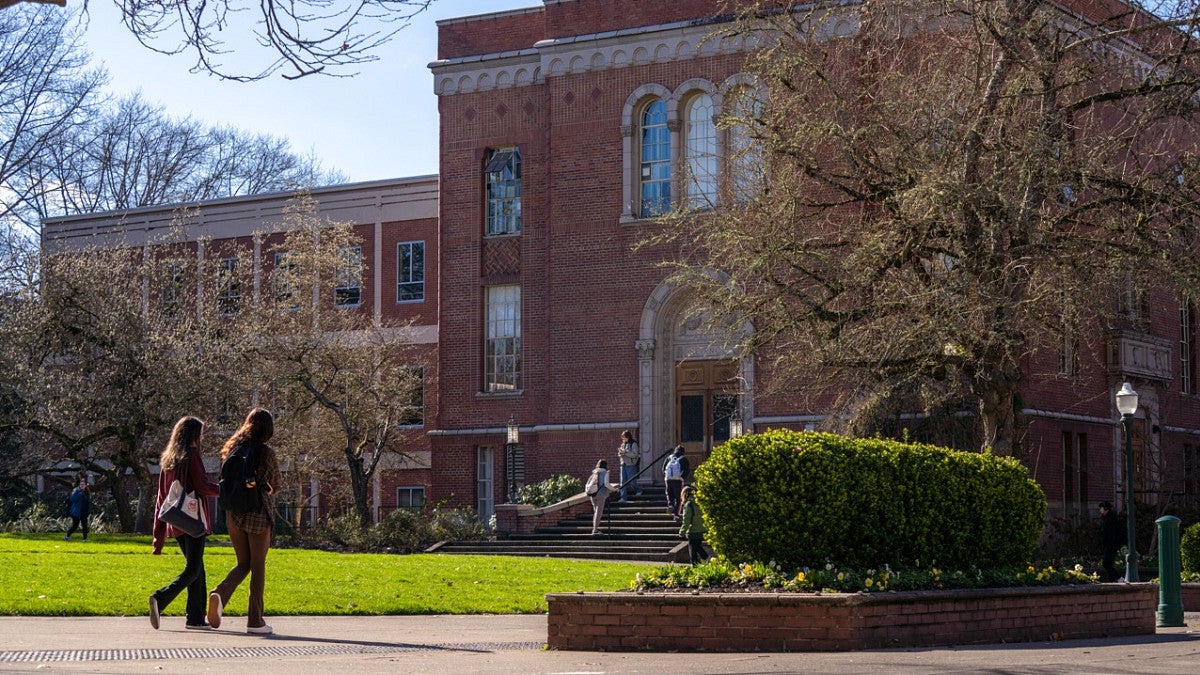 exterior building of Condon Hall with students walking by on a sunny day