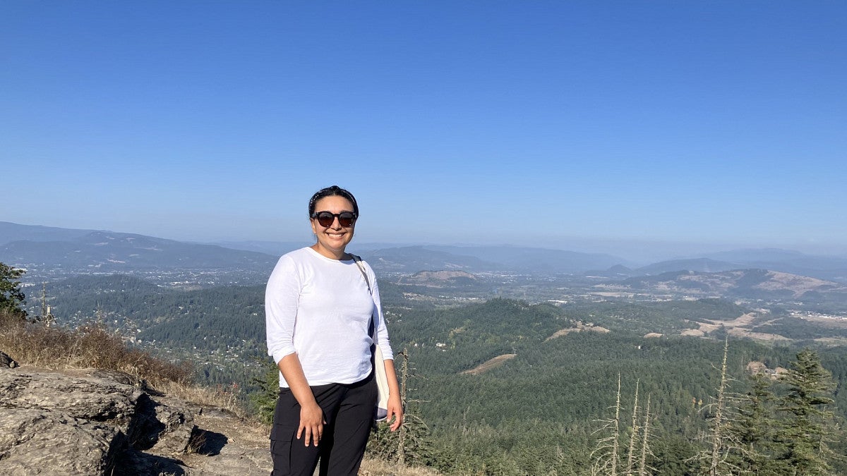 a person standing on top of mountain with a blue sky in the background