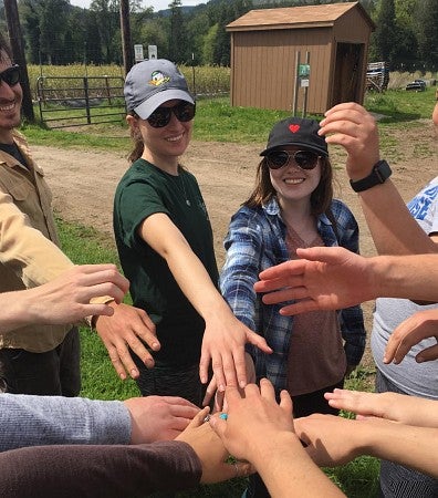 Students in a huddle at outdoor work site