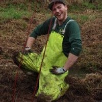 ELP 2014-2015 student in overalls kneeling in mud