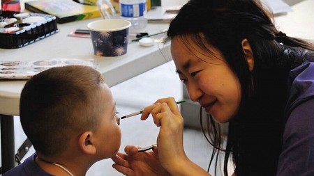 Nayeon Kim paints a child's face