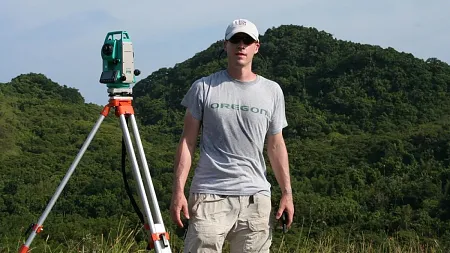 Scott Fitzpatrick with surveying equipment on the island of Palau in Micronesia