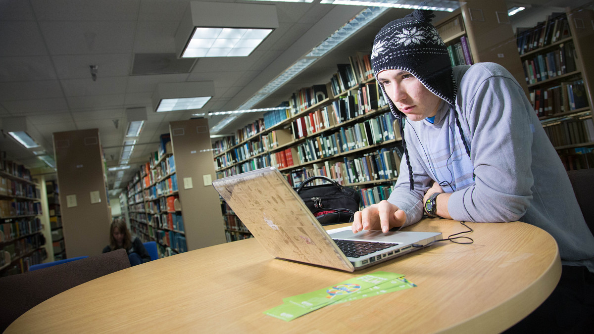 student concentrating while working on laptop