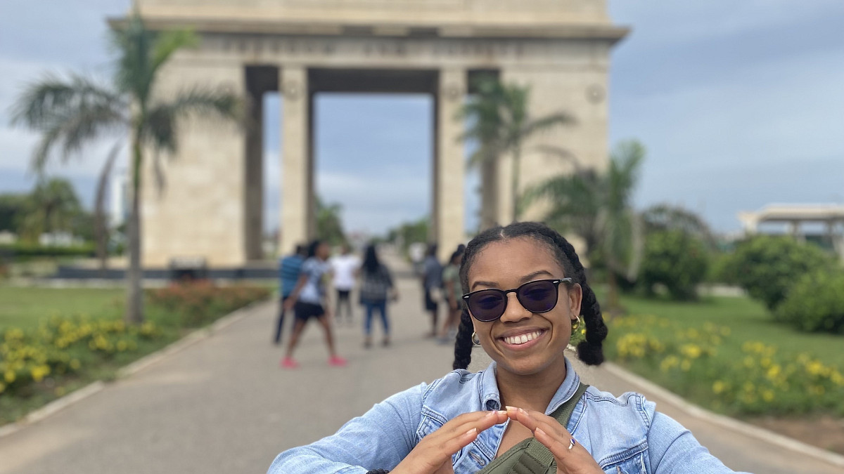Student in front of an arch in Ghana