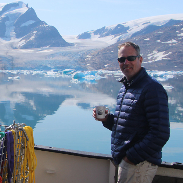 Mark Carey holding a cup of coffee on research trip