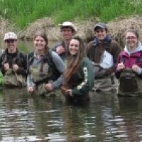 students wearing waders in river